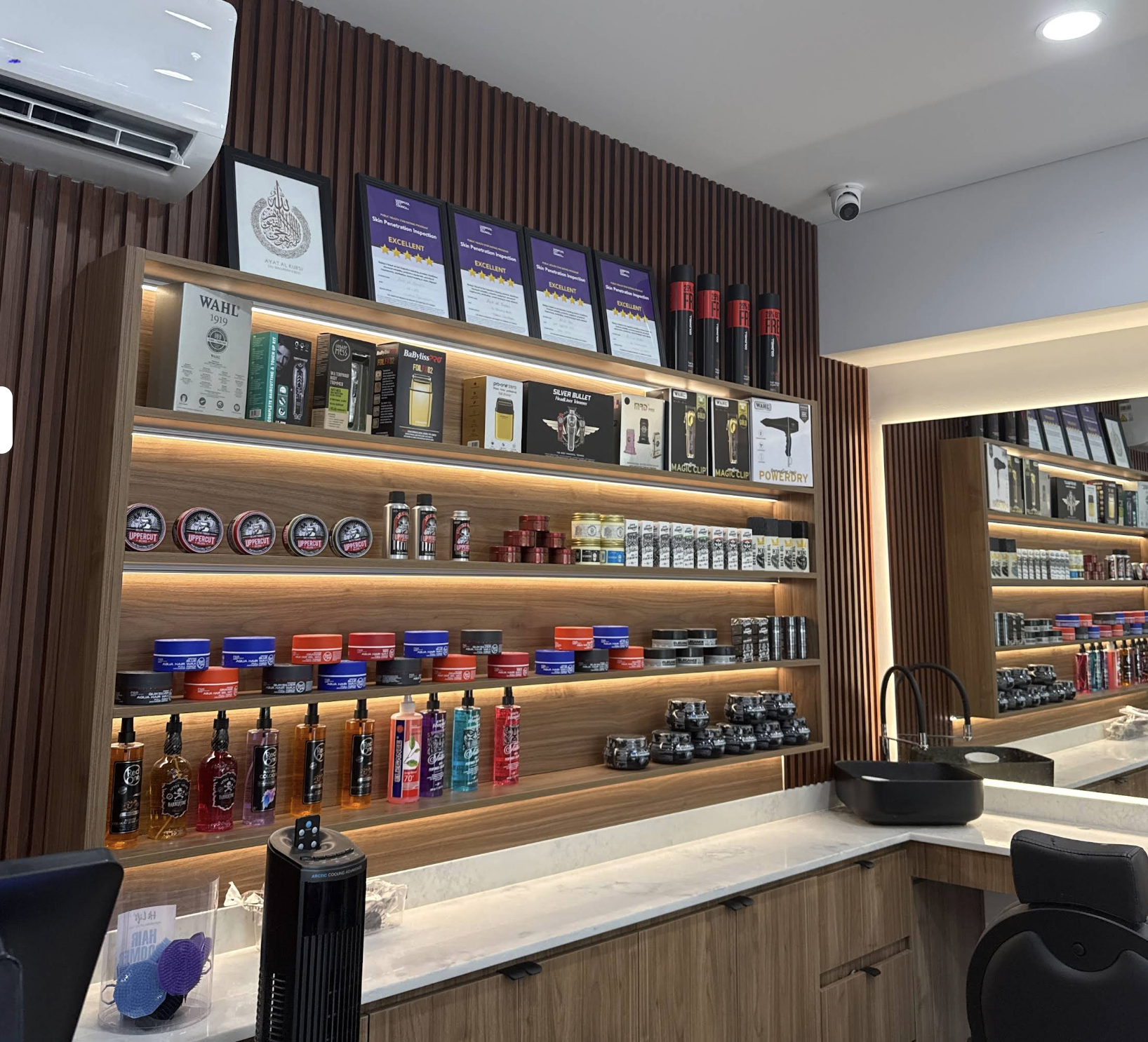 Backlit grooming products inside Art of Fades Barbershop