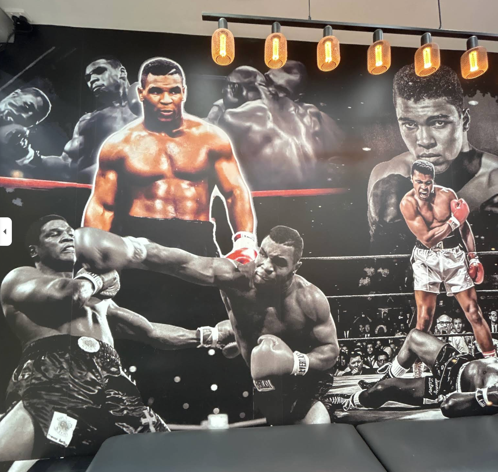 Boxing mural and warm pendant lights inside Art of Fades Barbershop
